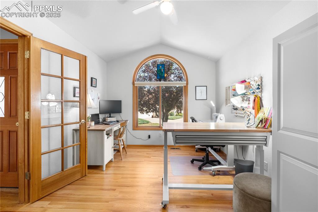 Image 2 of 49: Office space with vaulted ceiling, ceiling fan, and light wood-type floorin