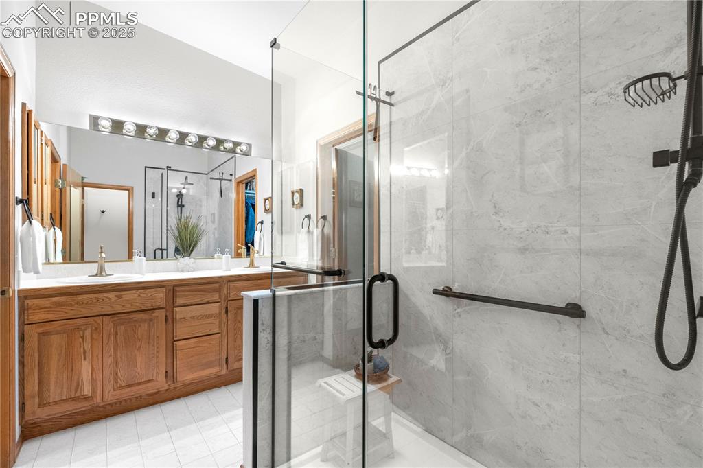 Image 26 of 49: Full bathroom with a shower stall and double vanity