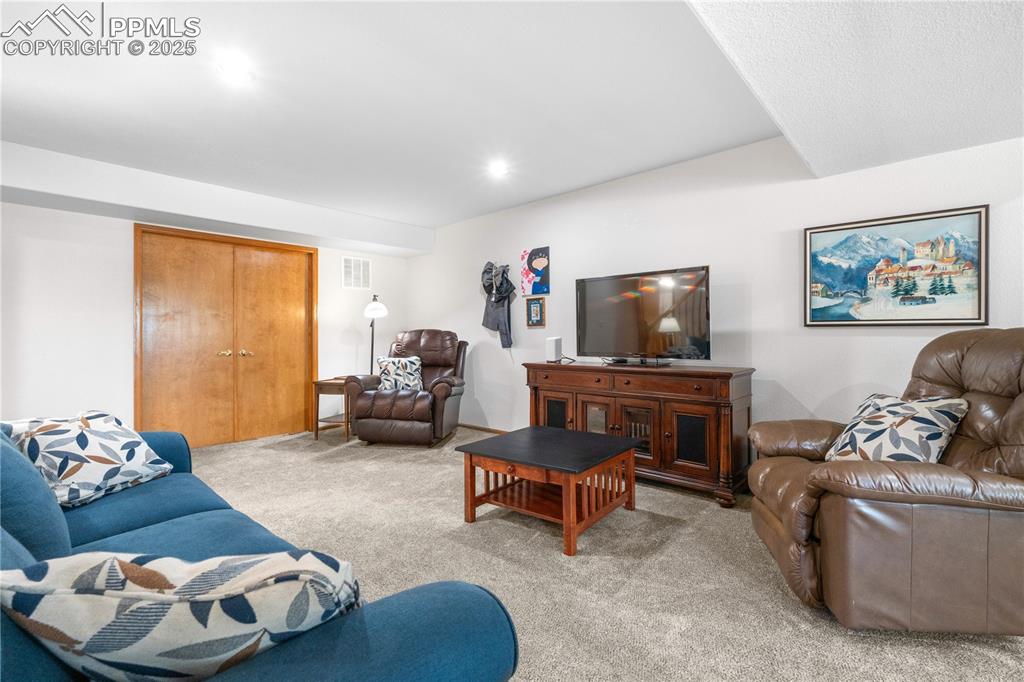 Image 32 of 49: Living room with light carpet and recessed lighting