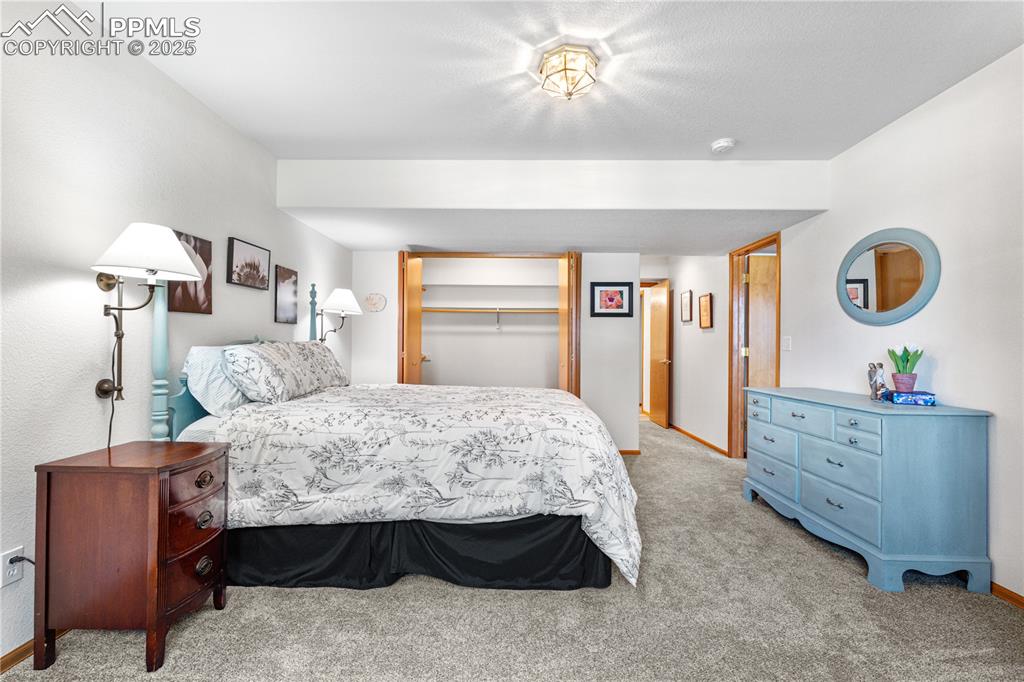 Image 34 of 49: Bedroom with light colored carpet and baseboards