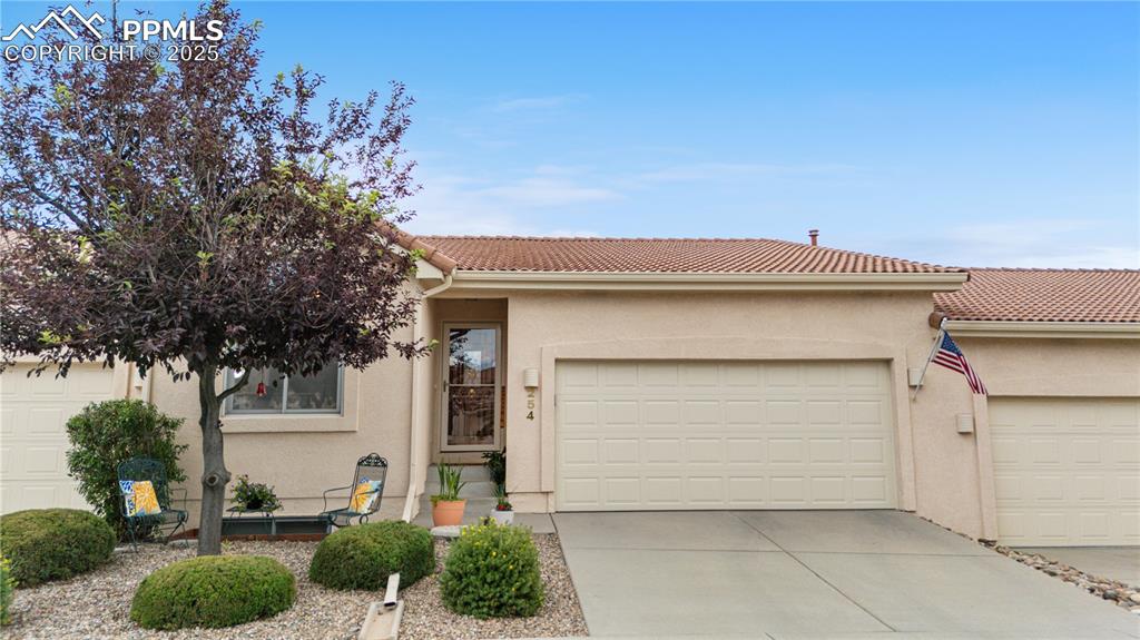 Image 41 of 49: View of front facade with stucco siding, concrete driveway, an attached gar