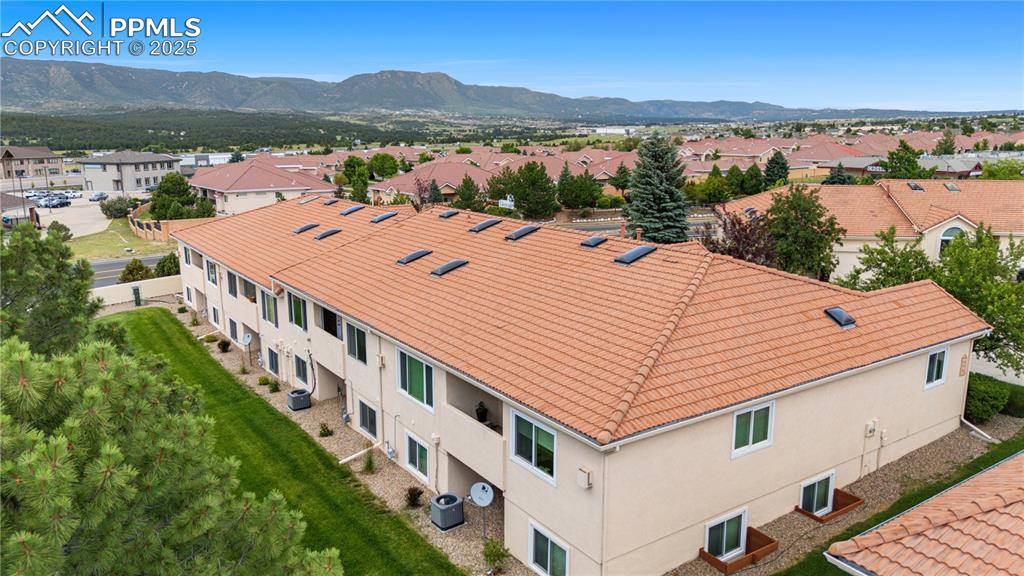 Image 46 of 49: Aerial view of residential area with a mountainous background