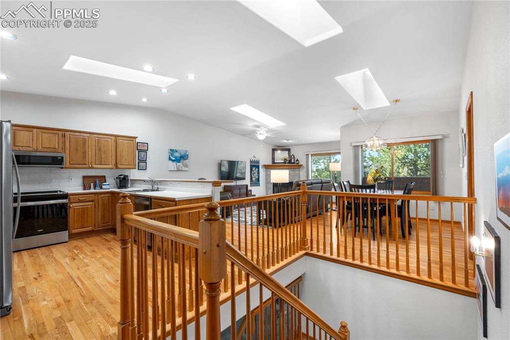 Image 5 of 49: Kitchen with a skylight, appliances with stainless steel finishes, vaulted