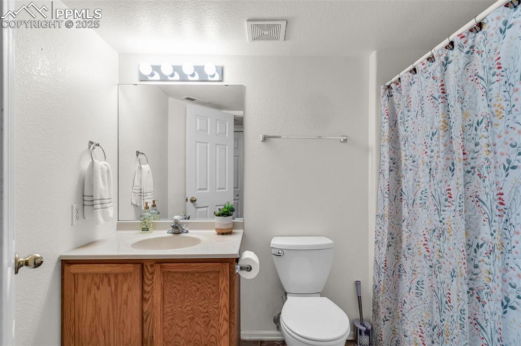 Image 10 of 20: Bathroom with vanity and curtained shower