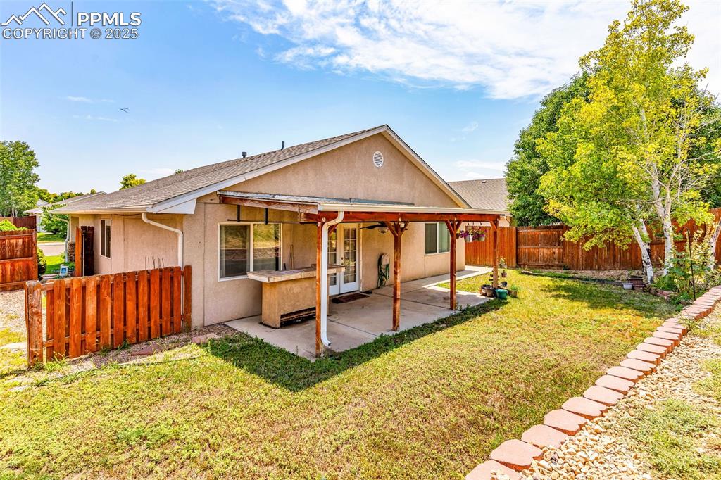 Image 17 of 20: Back of property featuring stucco siding, a fenced backyard, a patio, ceili