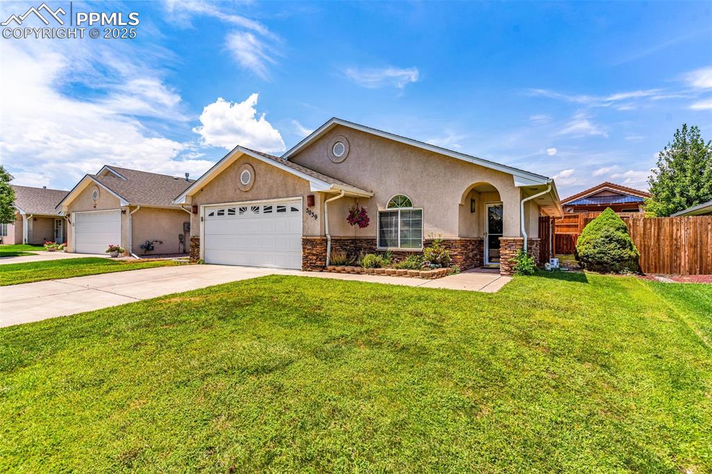 Image 2 of 20: View of front of home featuring stucco siding, an attached garage, concrete