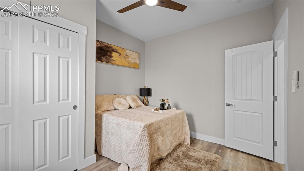 Image 14 of 36: Bedroom with light wood-style flooring, ceiling fan, and a closet