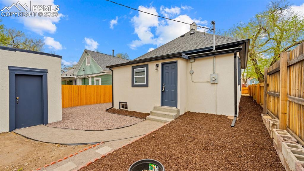 Image 26 of 36: Back of property with a fenced backyard, stucco siding, roof with shingles,