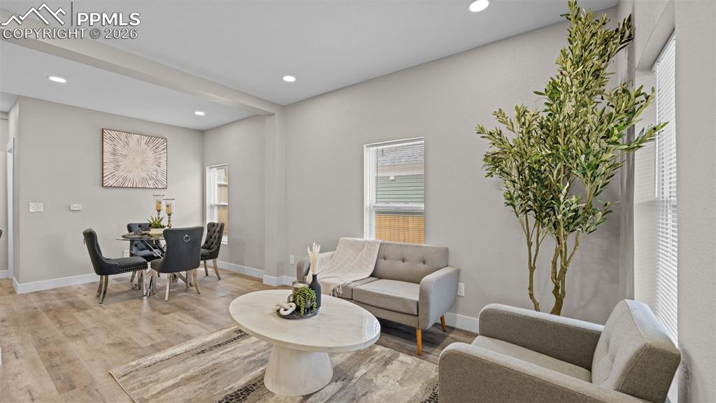 Image 5 of 36: Sitting room with light wood finished floors and recessed lighting