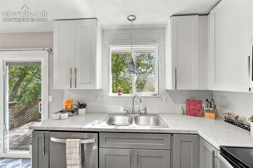 Image 11 of 46: Kitchen featuring light and dark cabinetry, a dual basin stainless steel si