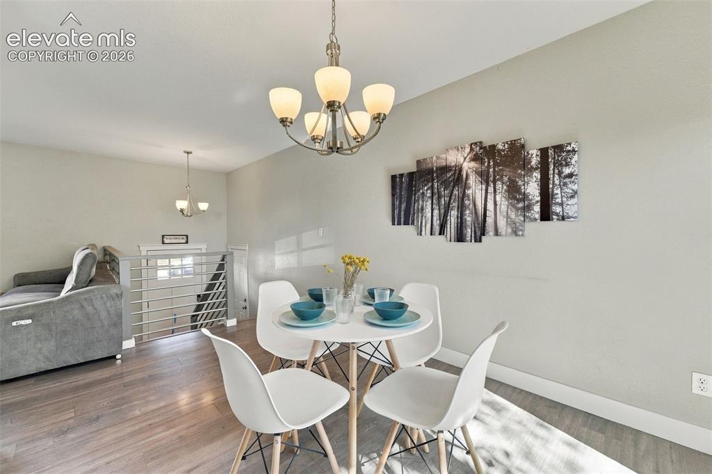 Image 14 of 46: Wood-finish flooring throughout, complemented by a contemporary chandelier