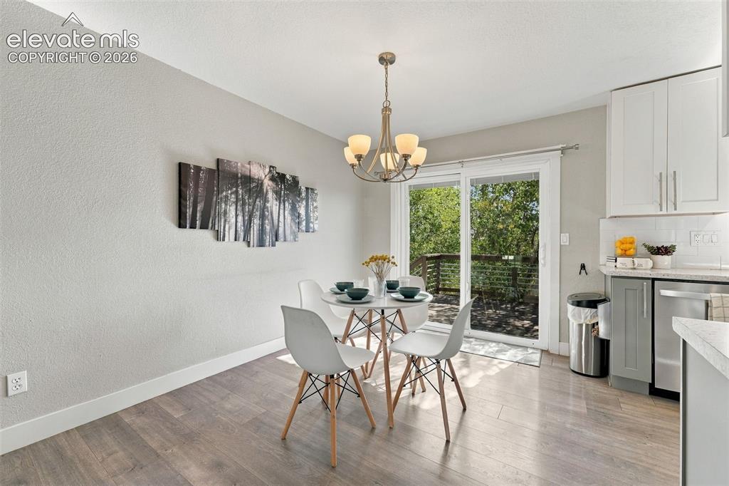 Image 15 of 46: Wood-finish flooring with white baseboards, sliding glass door, overhead ch