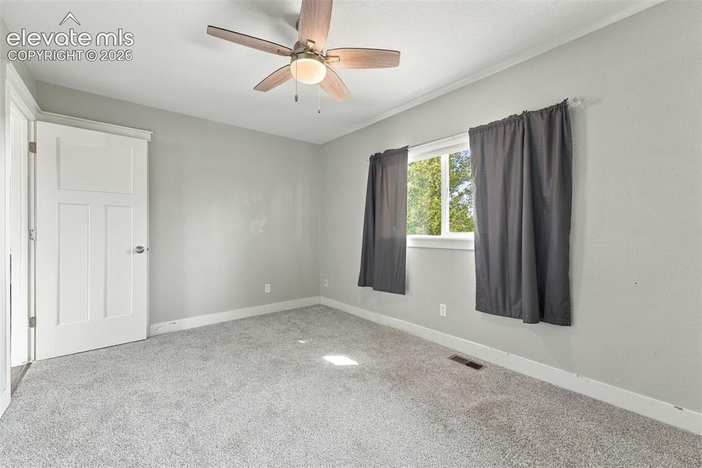 Image 17 of 46: Plush carpeting, a ceiling fan with integrated lighting, and white trim wor