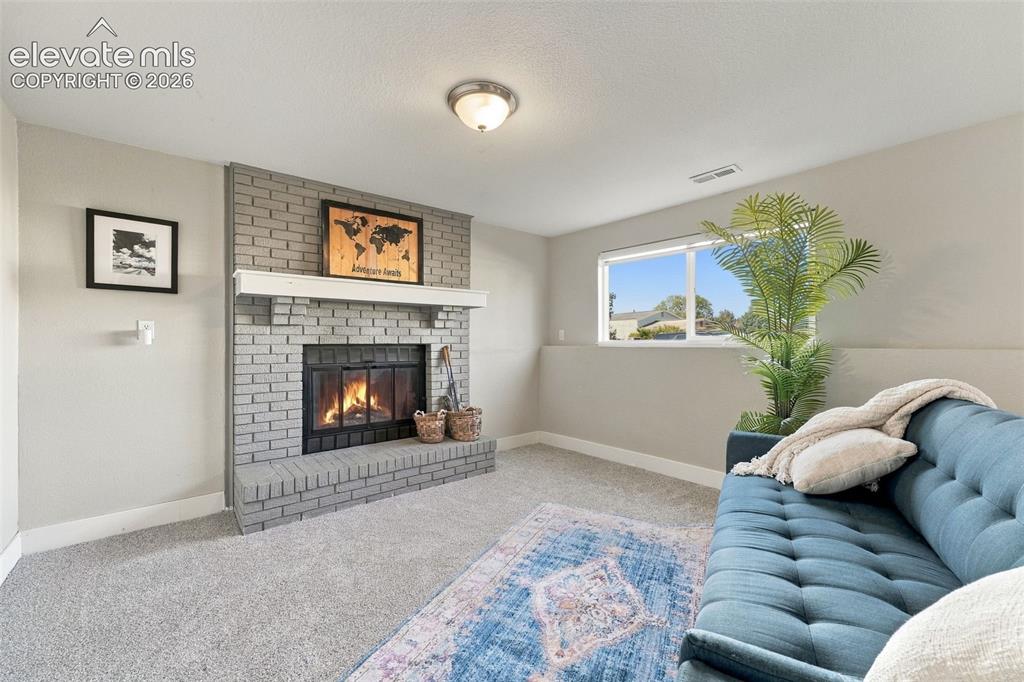 Image 25 of 46: Recessed window with exterior scenery, light gray brick fireplace with a wh