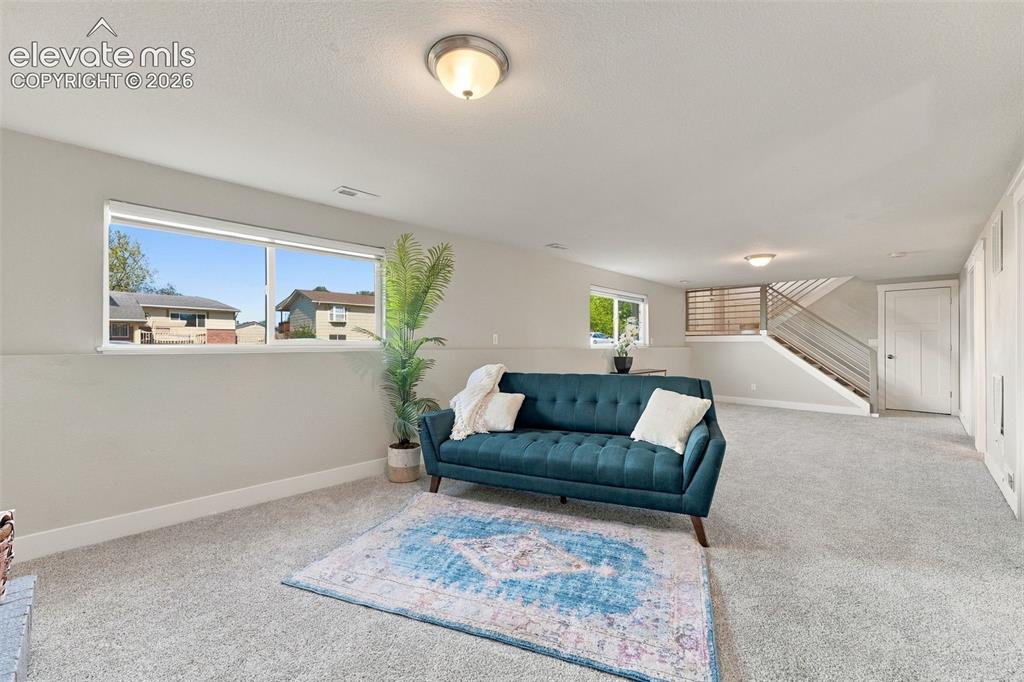 Image 28 of 46: Carpeted living space with multiple windows, recessed ceiling light, and a 
