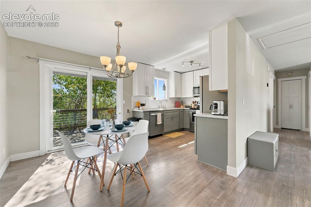 Image 4 of 46: Open-concept living area featuring wood-finish flooring, a contemporary cha