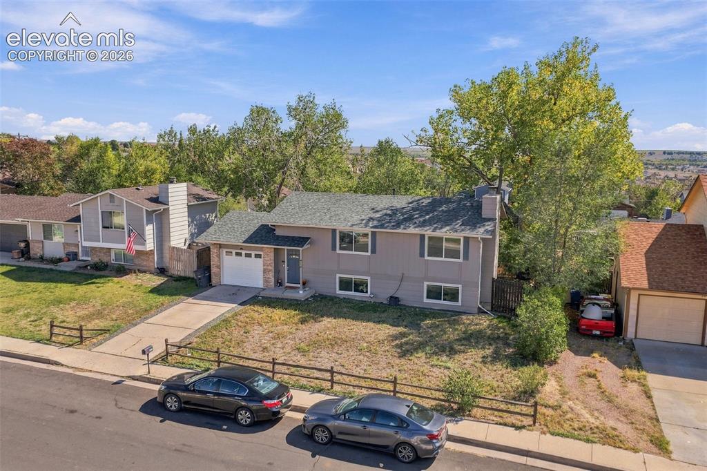 Image 42 of 46: Split-level residence featuring a two-car attached garage, a paved driveway