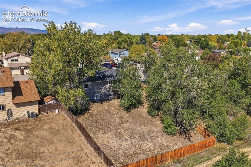 Image 43 of 46: Expansive lot featuring mature trees and a wooden privacy fence
