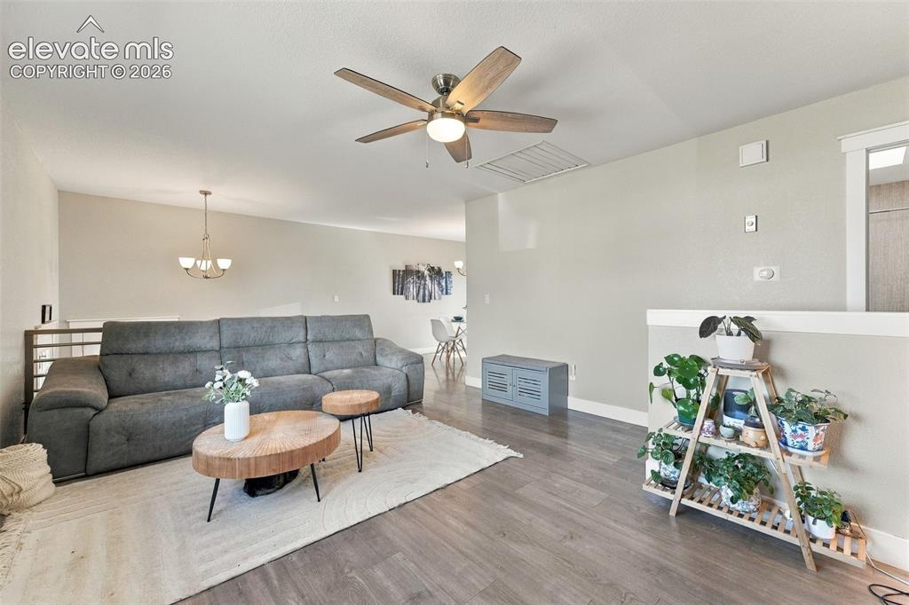Image 5 of 46: Wood-finish flooring throughout, with a ceiling fan with integrated lightin