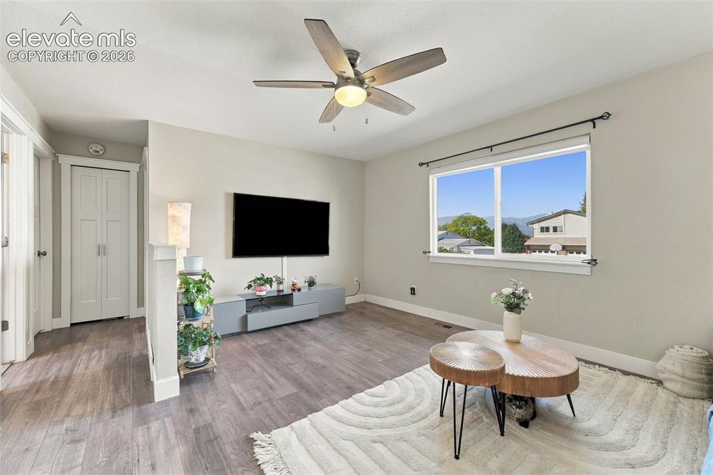 Image 7 of 46: Wood-finish flooring throughout, ceiling fan with integrated lighting, wind