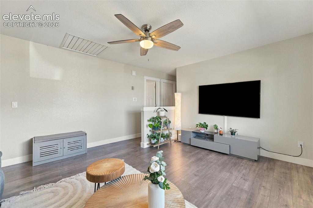 Image 8 of 46: Wood-finish flooring with a ceiling fan light fixture and a wall-mounted di