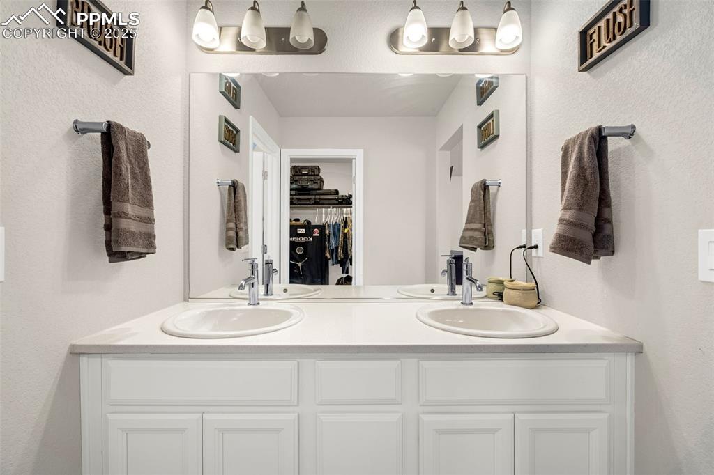 Image 10 of 35: Bathroom with double vanity and a walk in closet