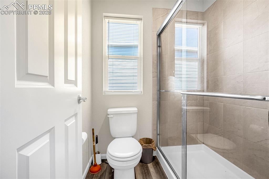 Image 11 of 35: Full bathroom featuring tiled shower and wood finished floors