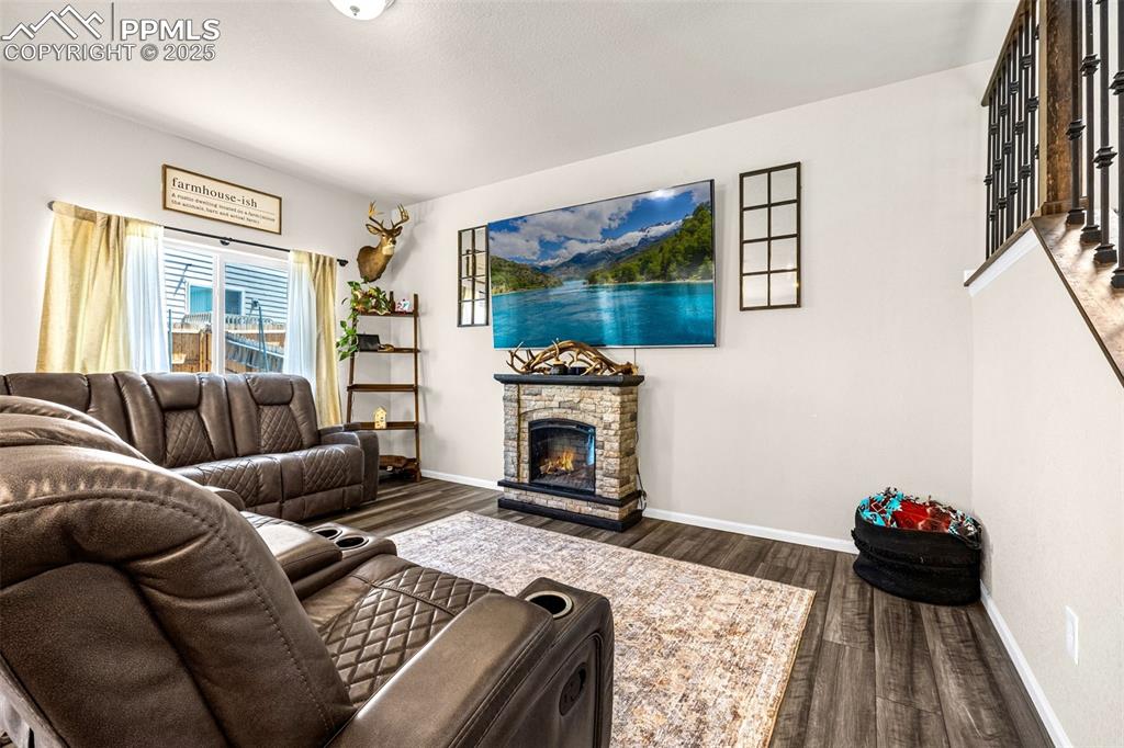Image 15 of 35: Living room with dark wood-style floors and a fireplace