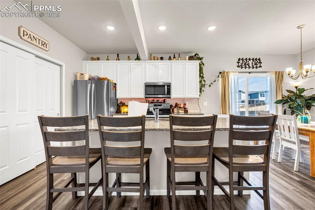 Image 18 of 35: Kitchen featuring appliances with stainless steel finishes, dark wood-type 