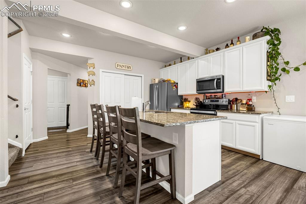 Image 19 of 35: Kitchen with stainless steel appliances, dark wood-style flooring, a kitche
