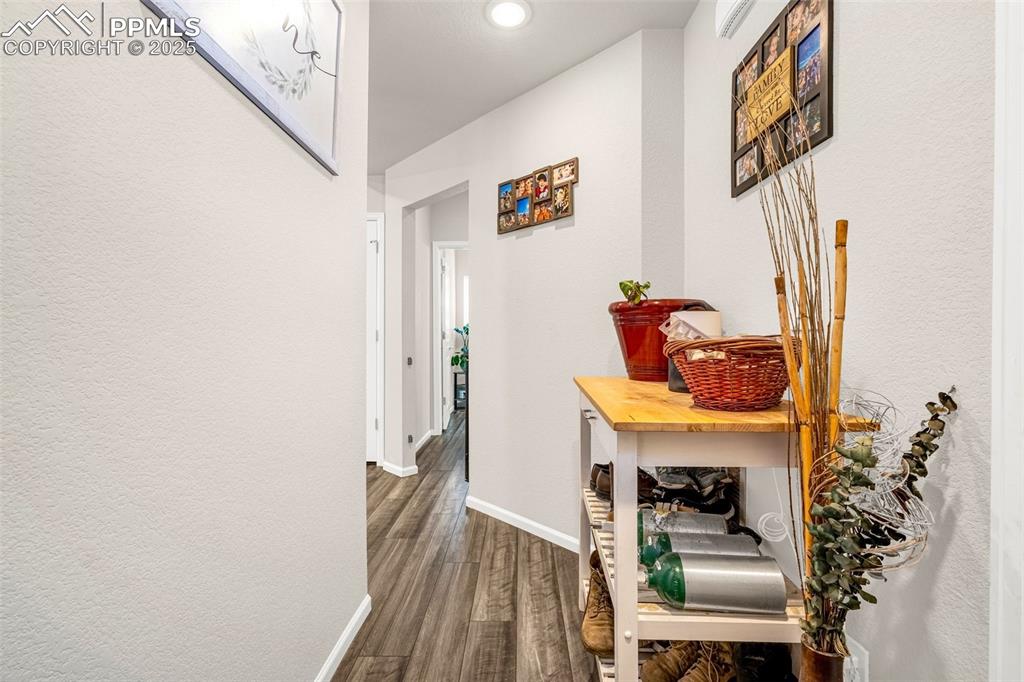 Image 23 of 35: Hall with dark wood finished floors and recessed lighting