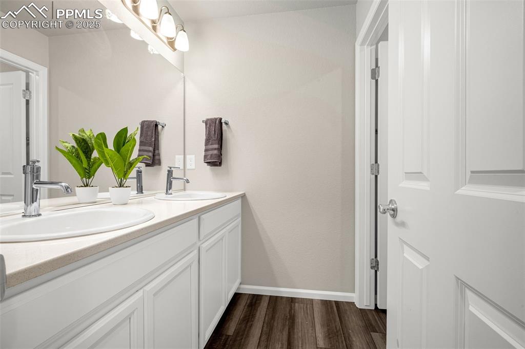 Image 4 of 35: Bathroom with double vanity and wood finished floors