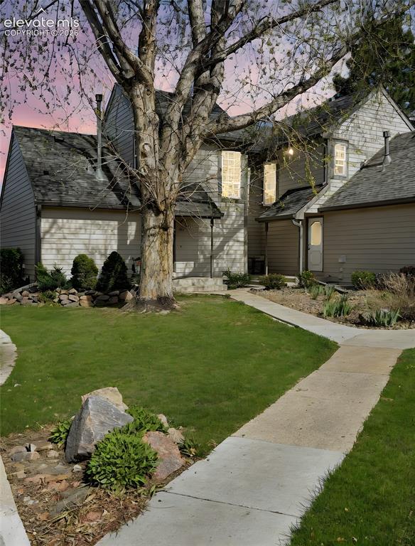 Image 1 of 44: Multi-level exterior with siding, a prominent mature tree, a manicured lawn