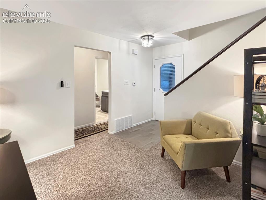 Image 10 of 44: Entryway featuring a carpeted floor, white trim, and a staircase with a dar