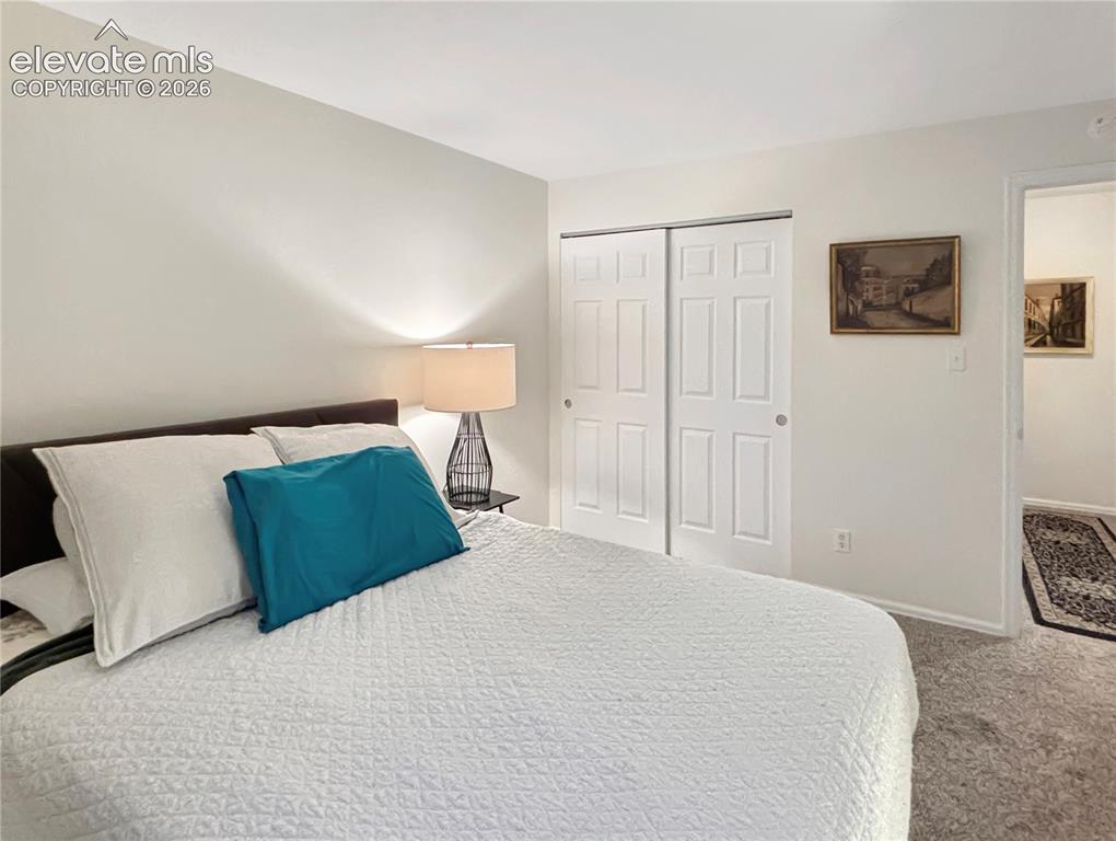 Image 14 of 44: Bedroom featuring light gray wall paint, white trim, and light-colored carp