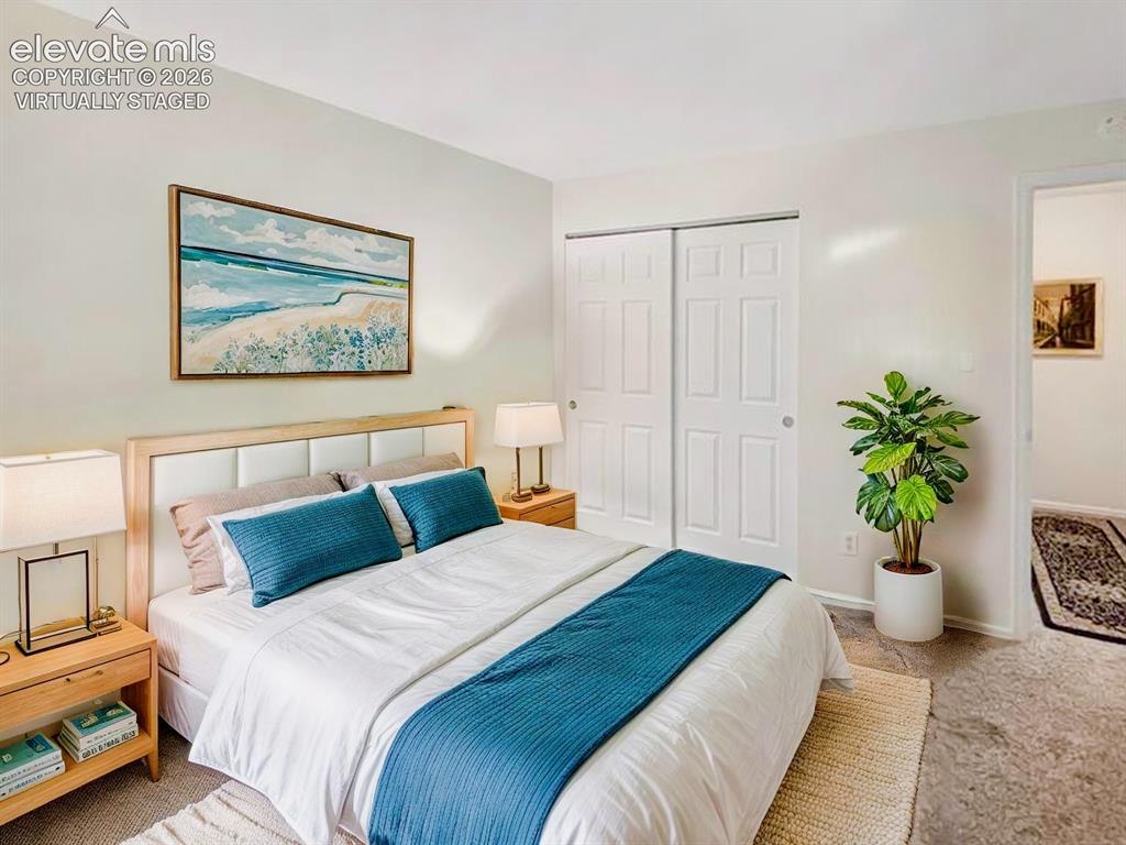 Image 15 of 44: Virtually Staged Well-lit bedroom featuring light-colored walls, carpeted f
