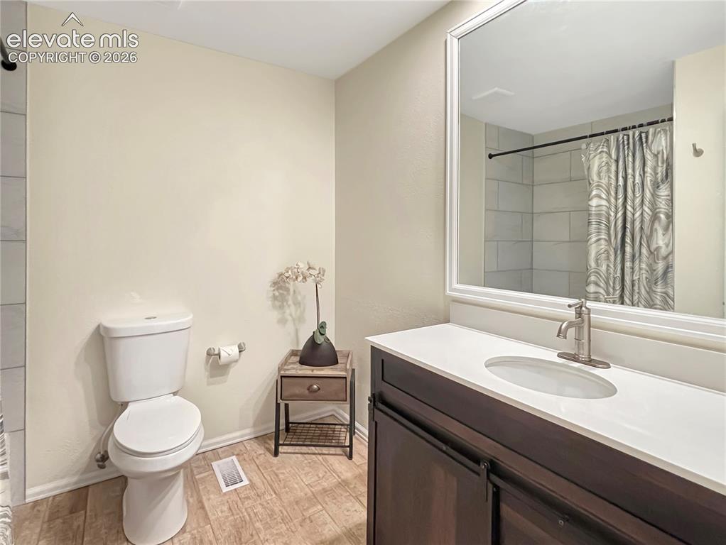 Image 17 of 44: Bathroom featuring a dark wood-finish vanity with a white countertop and un