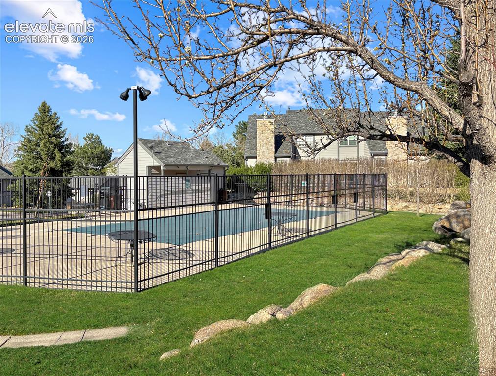 Image 26 of 44: Fenced outdoor pool area featuring a concrete deck and integrated seating