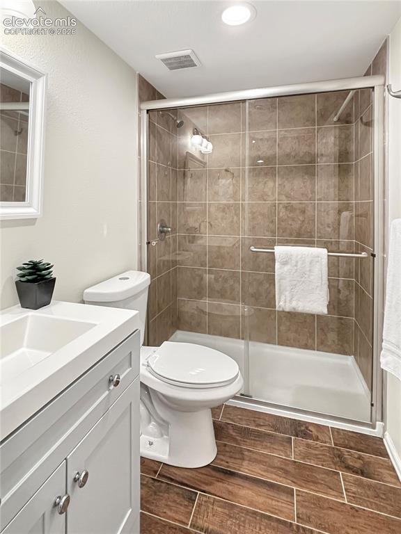 Image 35 of 44: Bathroom featuring a glass-enclosed shower with tile surround, a single van