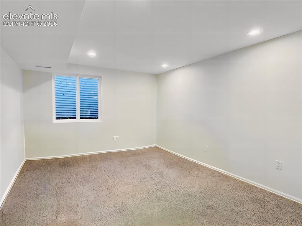 Image 38 of 44: Spacious room featuring neutral wall paint, recessed lighting, white basebo