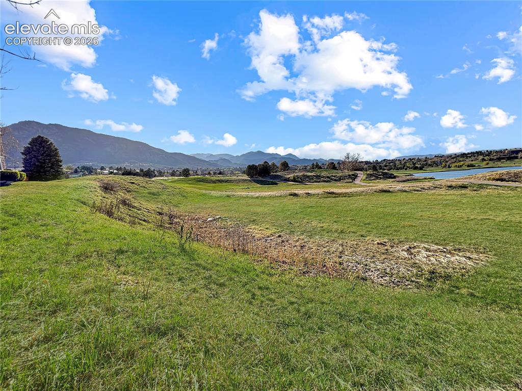 Image 44 of 44: Expansive green space featuring varied terrain with a distant body of water