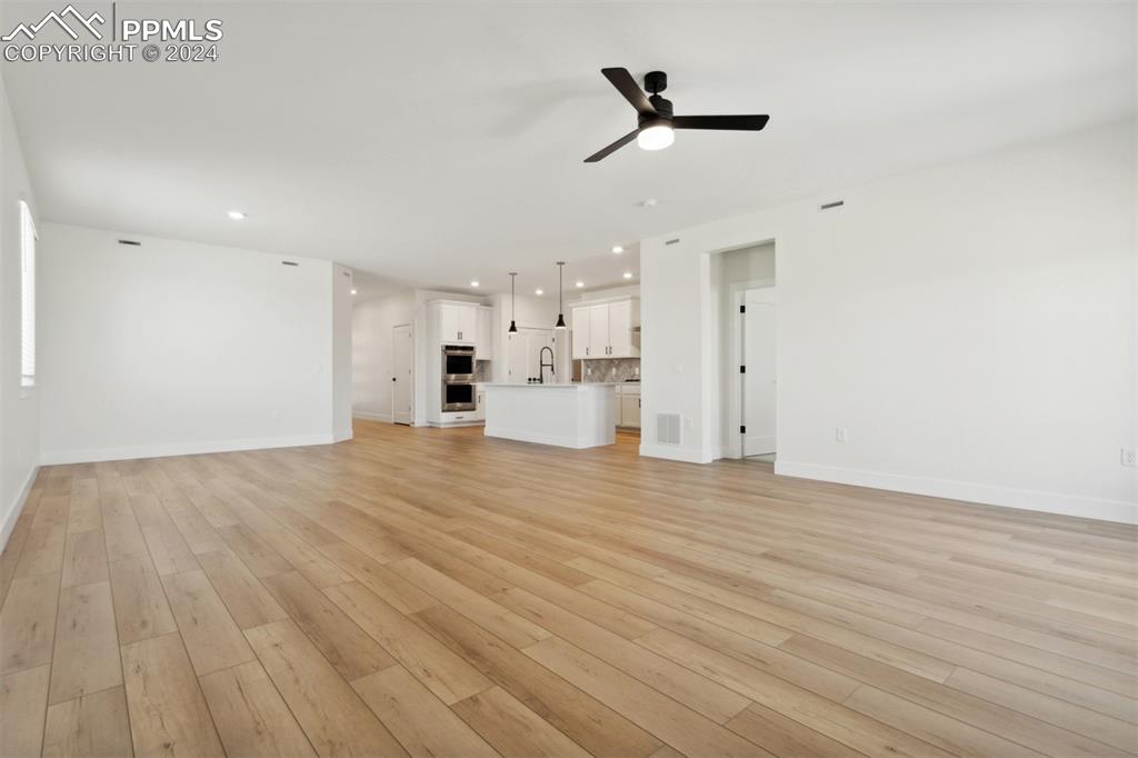 Image 5 of 15: Unfurnished living room featuring light hardwood / wood-style flooring, cei