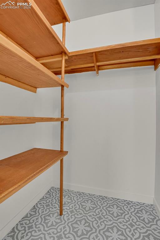 Image 23 of 40: Primary walk-in closet with original mid-century modern shelves!
