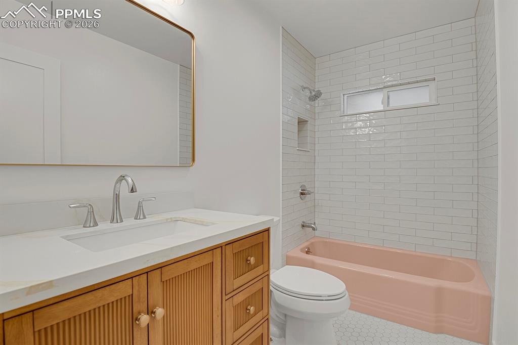 Image 31 of 40: Main full level bathroom with original castiron pink tub!