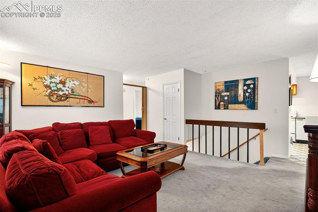 Image 17 of 37: Living area with carpet flooring and a textured ceiling