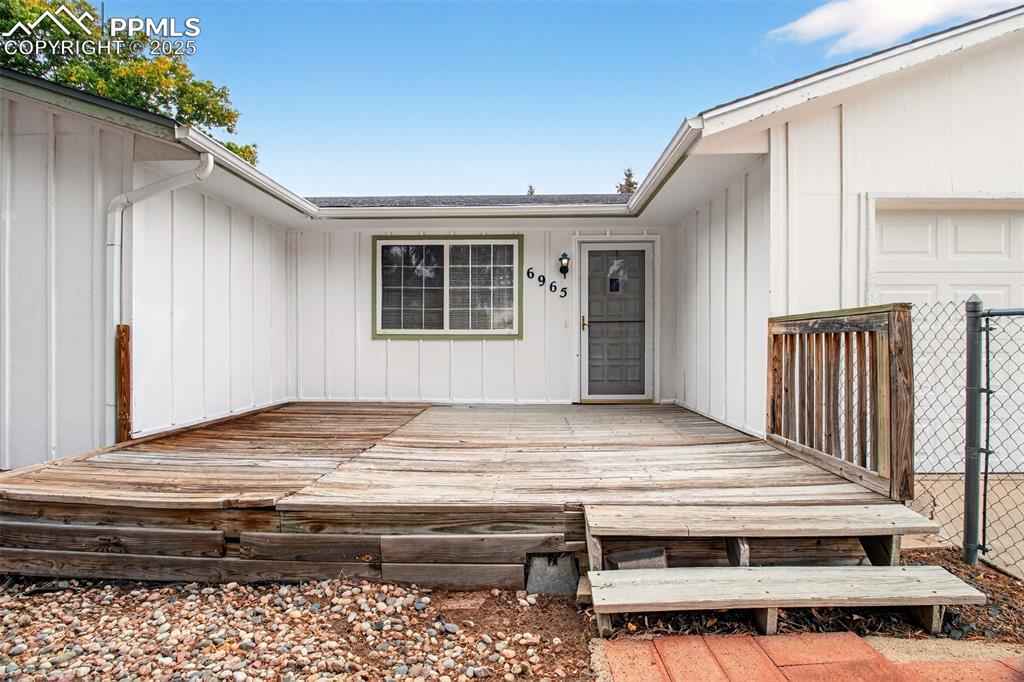 Image 25 of 37: Entrance to property featuring a deck and board and batten siding