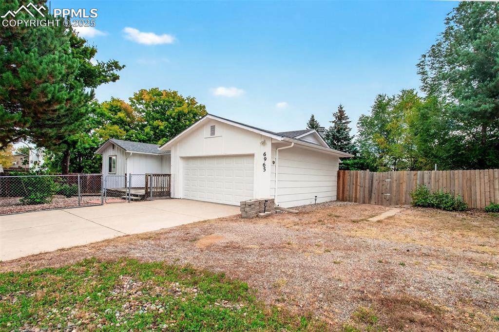 Image 26 of 37: View of side of home featuring driveway, 2 car garage and RV parking