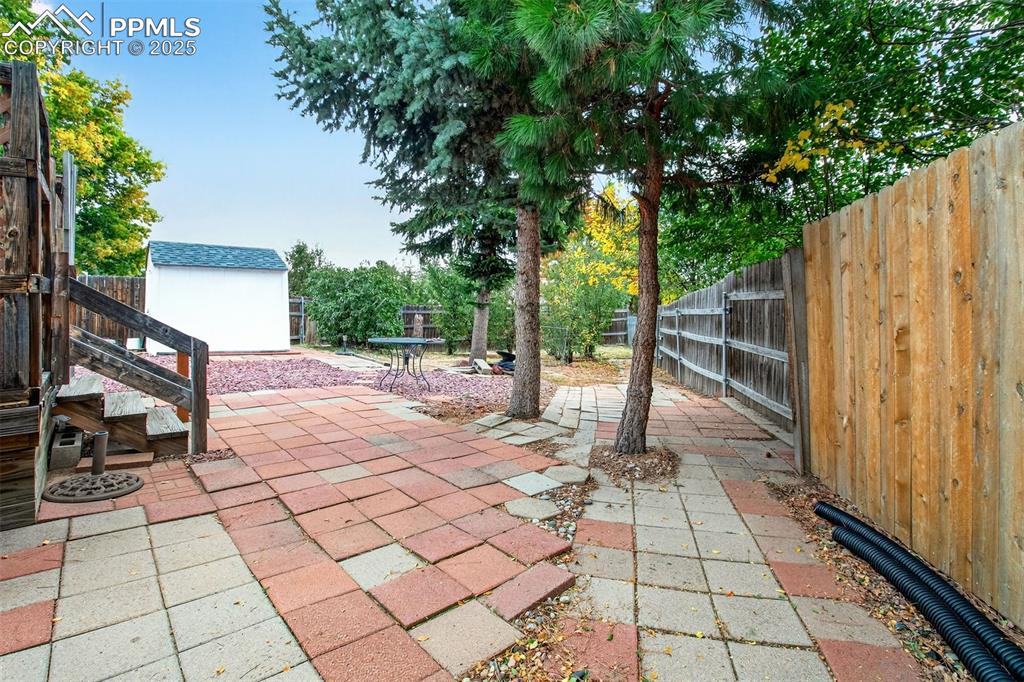 Image 35 of 37: Fenced backyard featuring a patio area and a shed