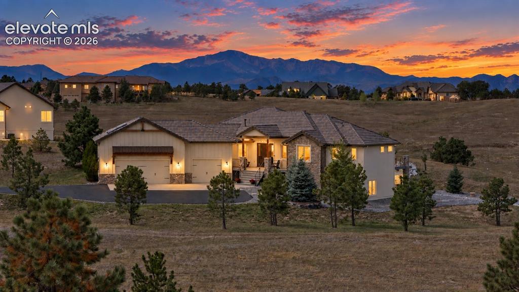 Caption: Expansive property with a paved driveway, attached multi-car garage, and a covered front entry