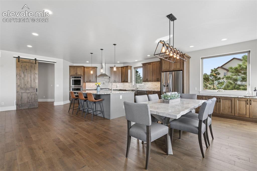 Image 11 of 50: Wood-finish flooring throughout, kitchen island with seating, built-in stai